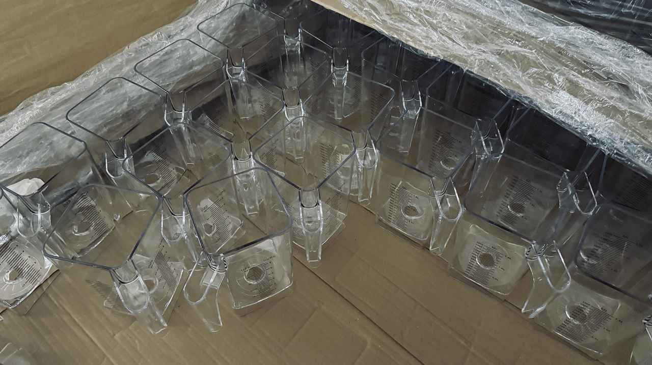 Food-grade transparent PC plastic jars and pitcher lids stored in factory inventory